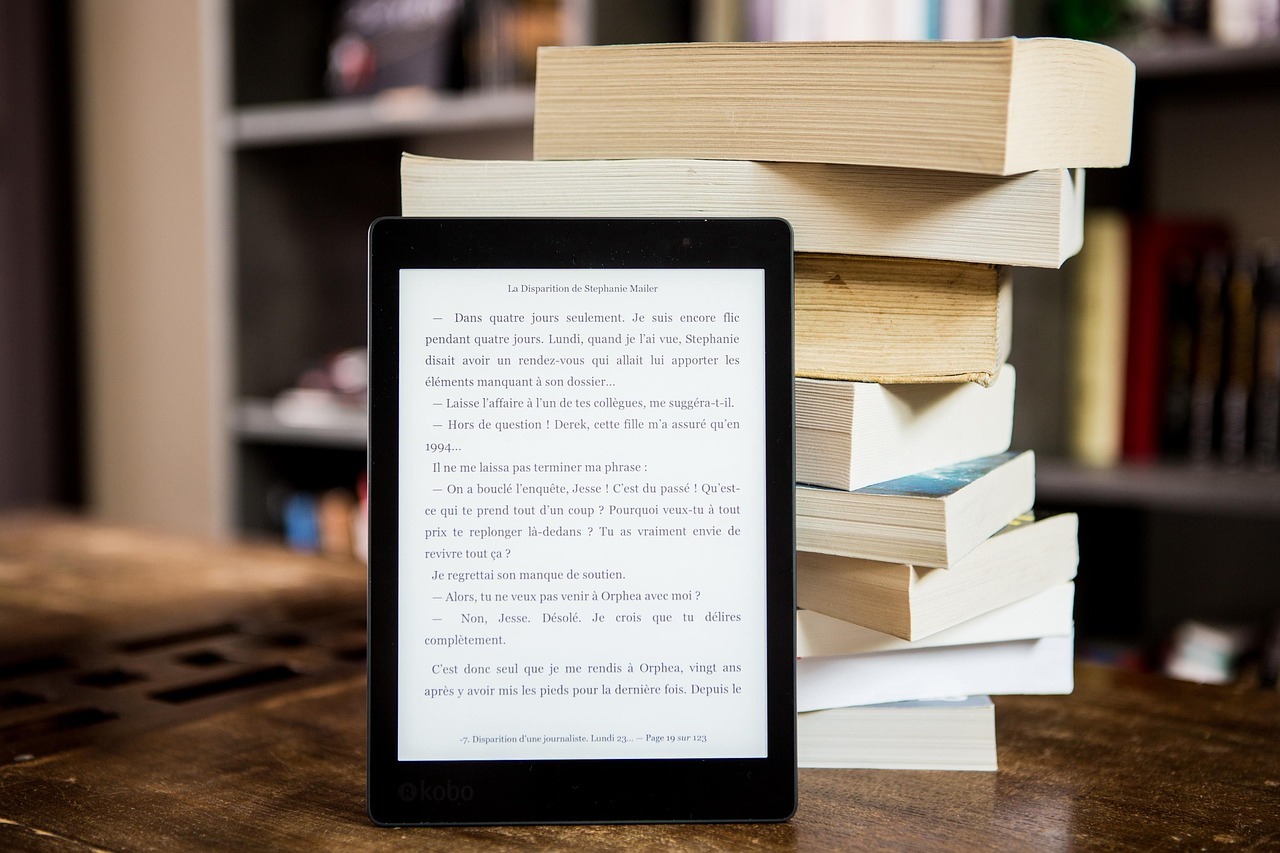 Kindle leaning against stack of books, symbolizing lifelong learning, personal development, and inspiration through digital and print reading Kindle leaning against stack of books, symbolizing lifelong learning, personal development, and inspiration through digital and print reading